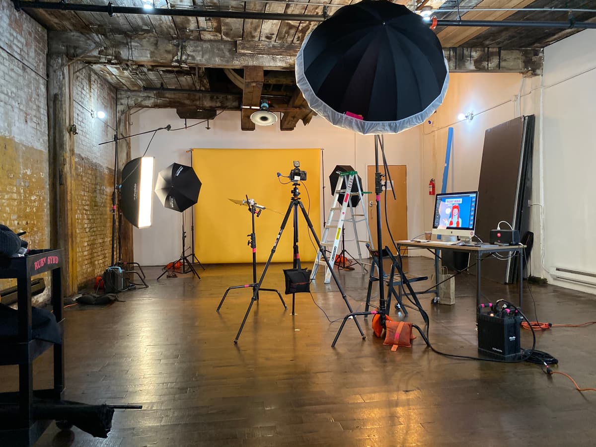 Studio setup with yellow backdrop and lighting equipment