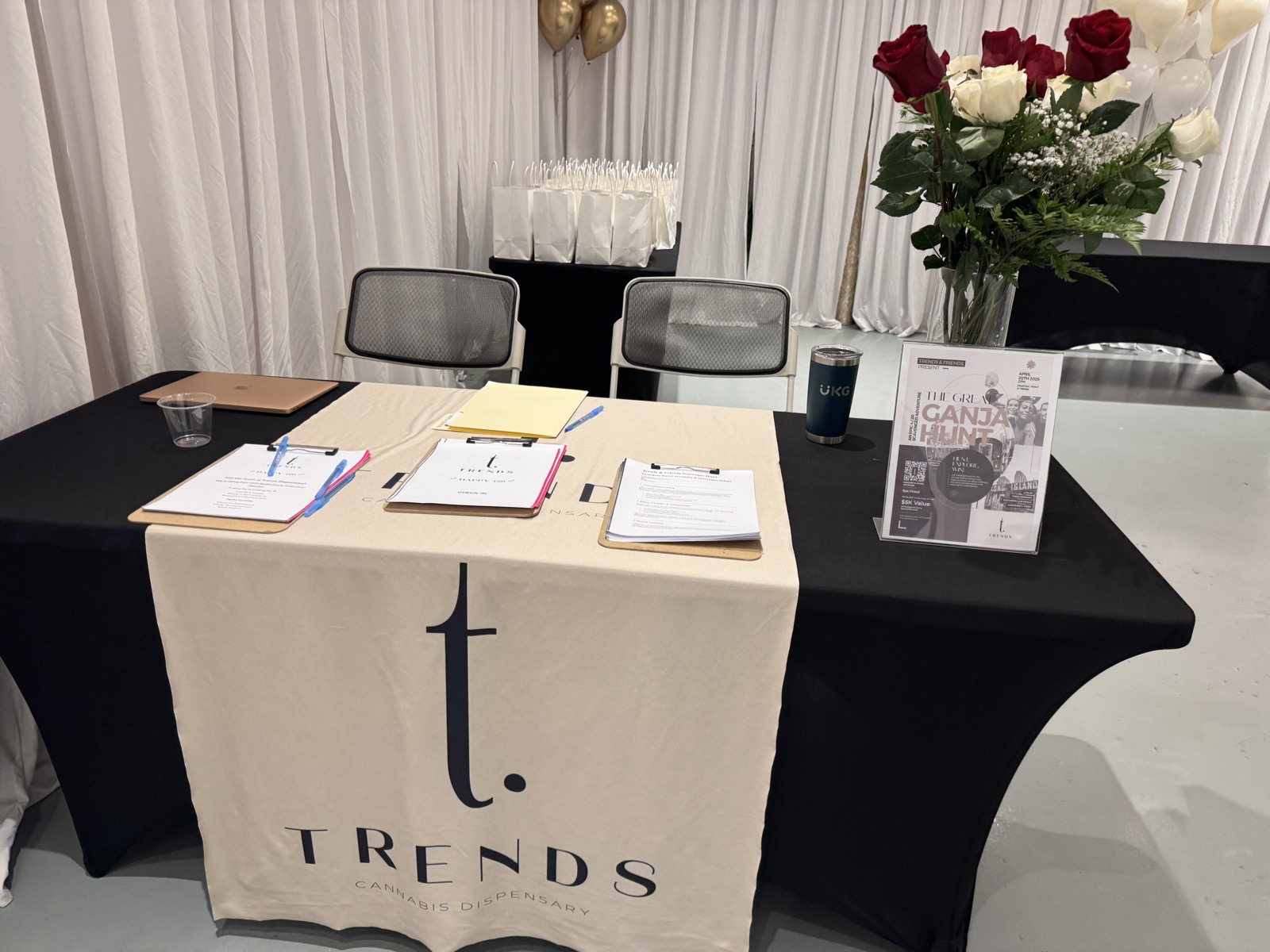 TRENDS registration table with branded signage, roses, and Ganja Hunt flyers